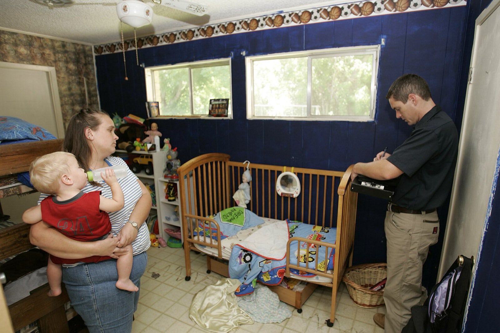 A flood-insurance damage inspector documenting flood damage inside a homeowner's house as part of filing a flood insurance claim