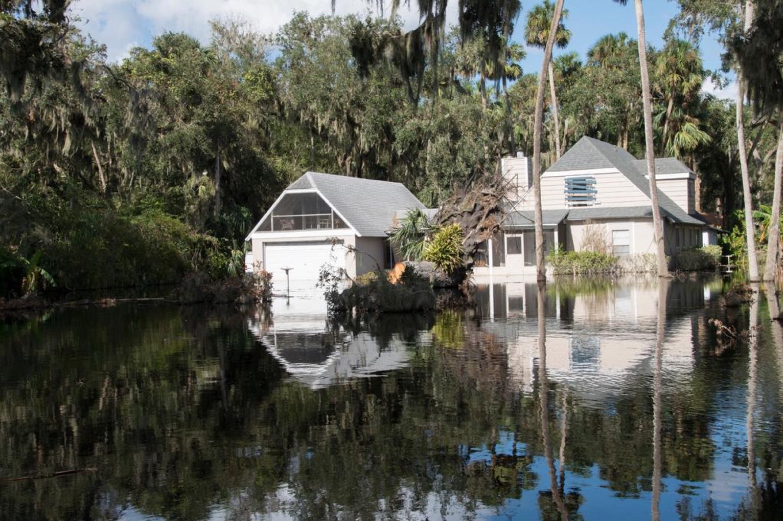 Floodwater surrounding a home's yard during a storm