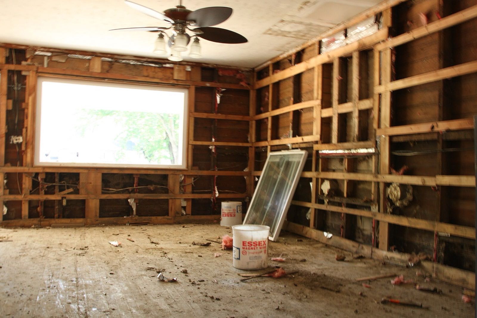 Gutted interior of a flood-damaged home with wet drywall and flooring removed so the structure can dry and prevent mold after water damage